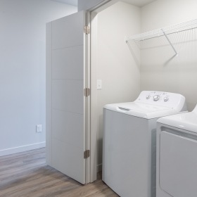 Washer/Dryer side-by-side washer/dryer in lighted laundry room with overhead shelf